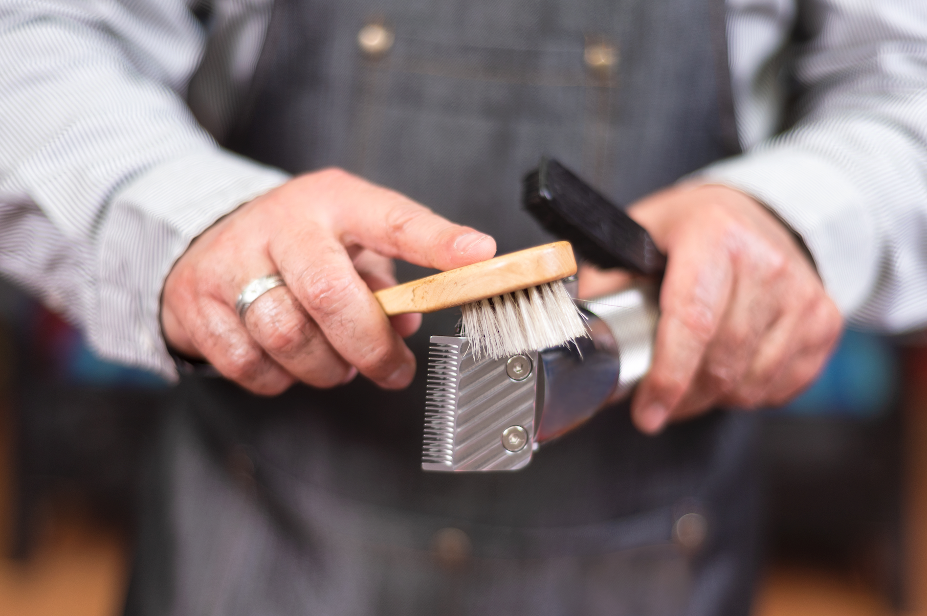 A man is cleaning a comb with a brush.
