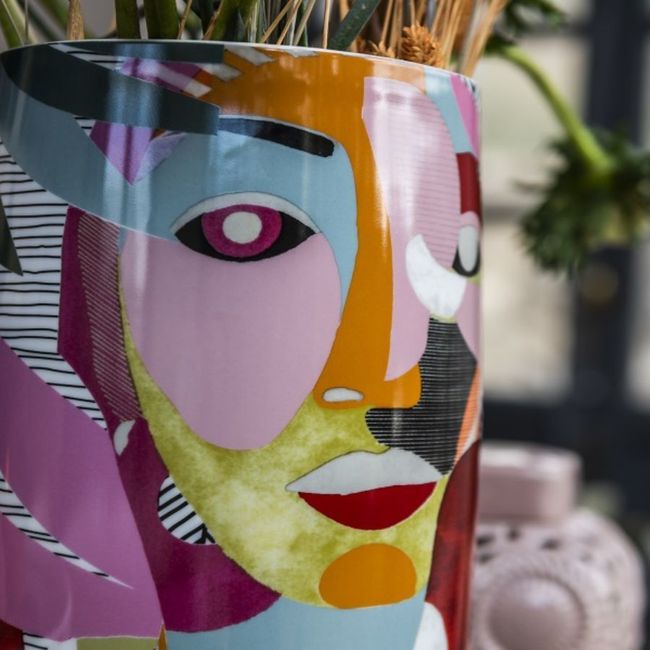 Un vaso in ceramica decorato con un volto astratto e colorato in stile cubista, nelle tonalità del rosa, giallo, blu e arancione.
