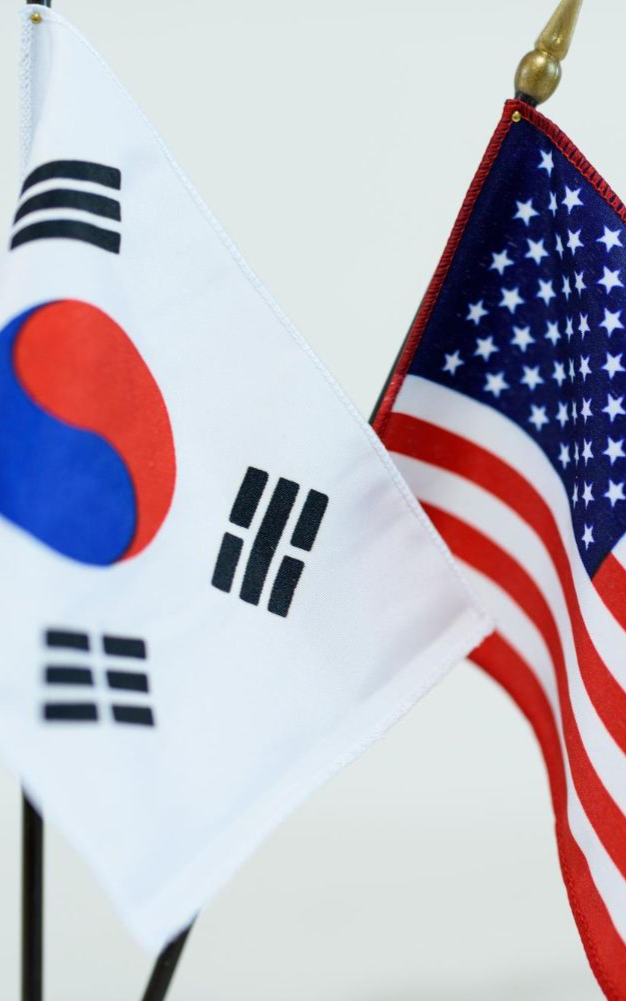 Flags of South Korea and the United States displayed side-by-side on poles.