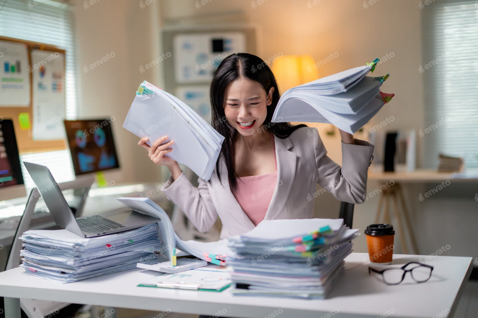 Three people in a cluttered clothing store, with one person seated and two standing while looking at a denim dress.