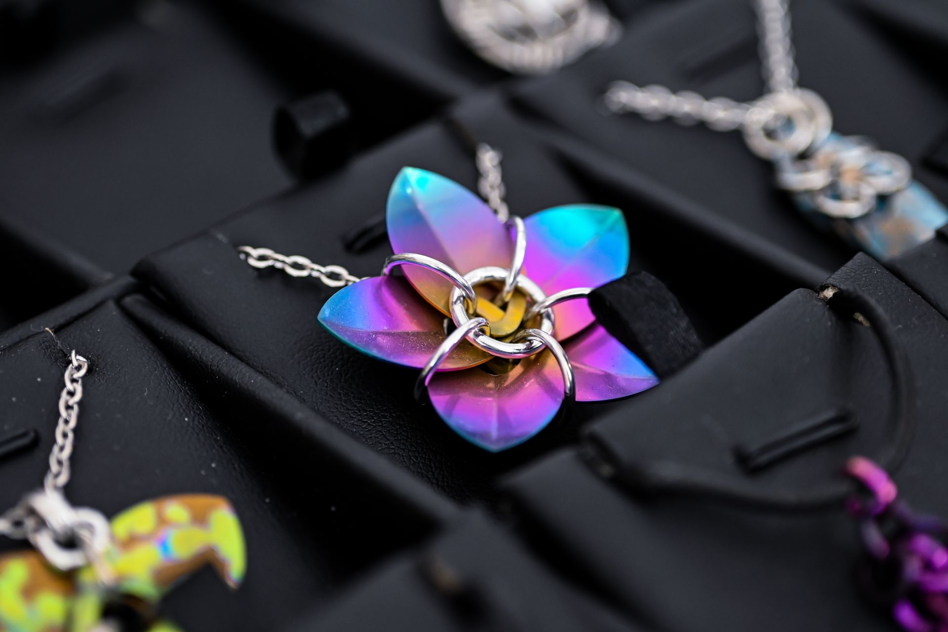 A necklace with a flower shaped pendant on a chain