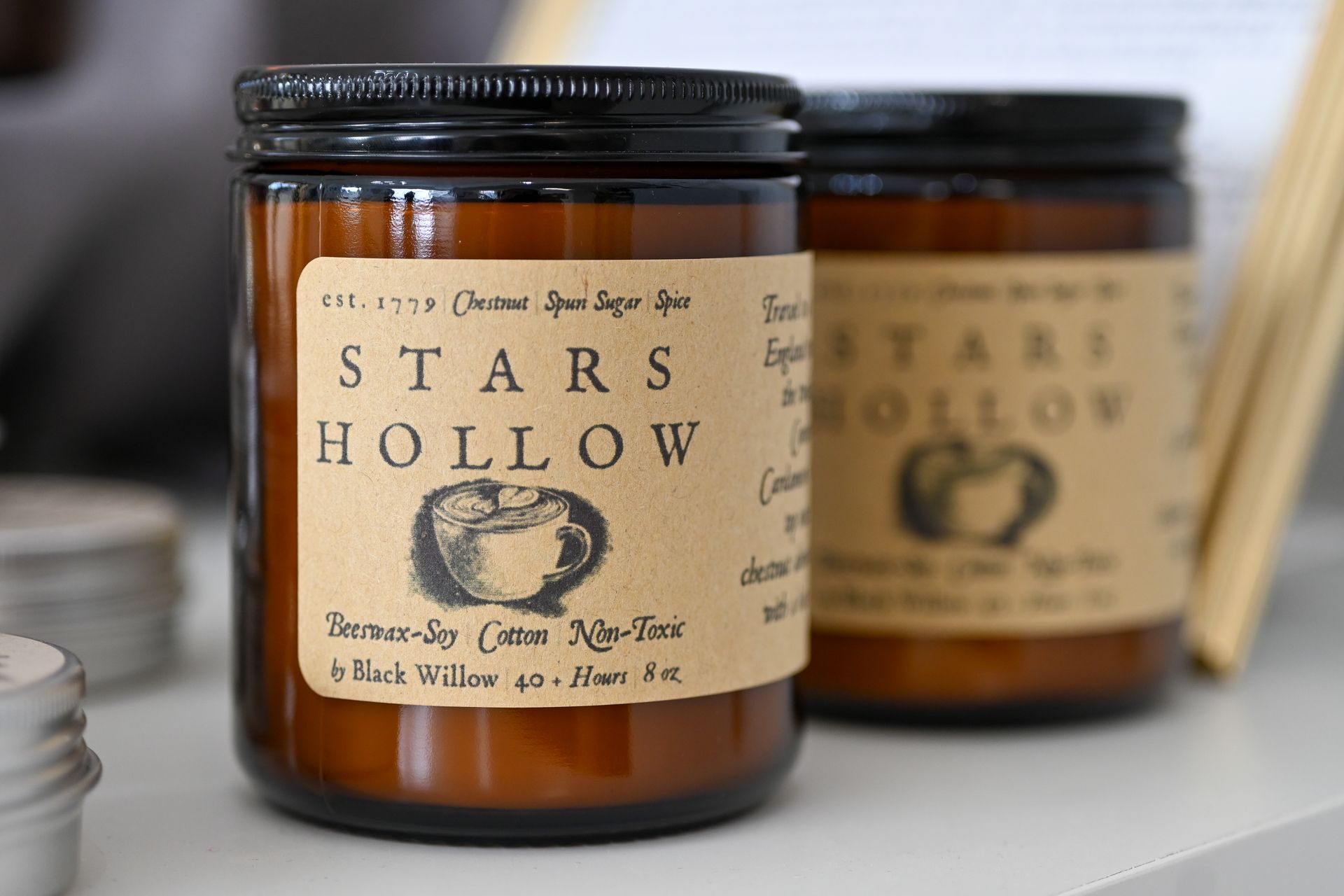 Two jars of stars hollow candles are sitting on a table.