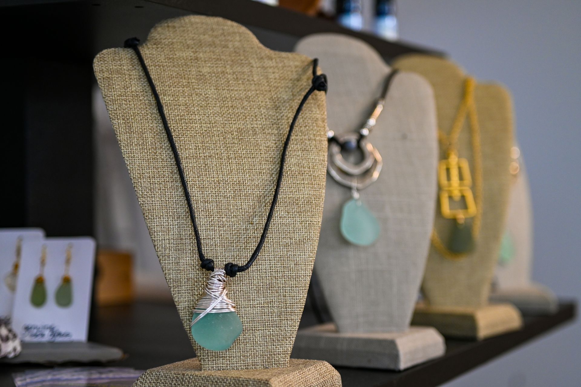 A row of mannequins with necklaces and earrings on them