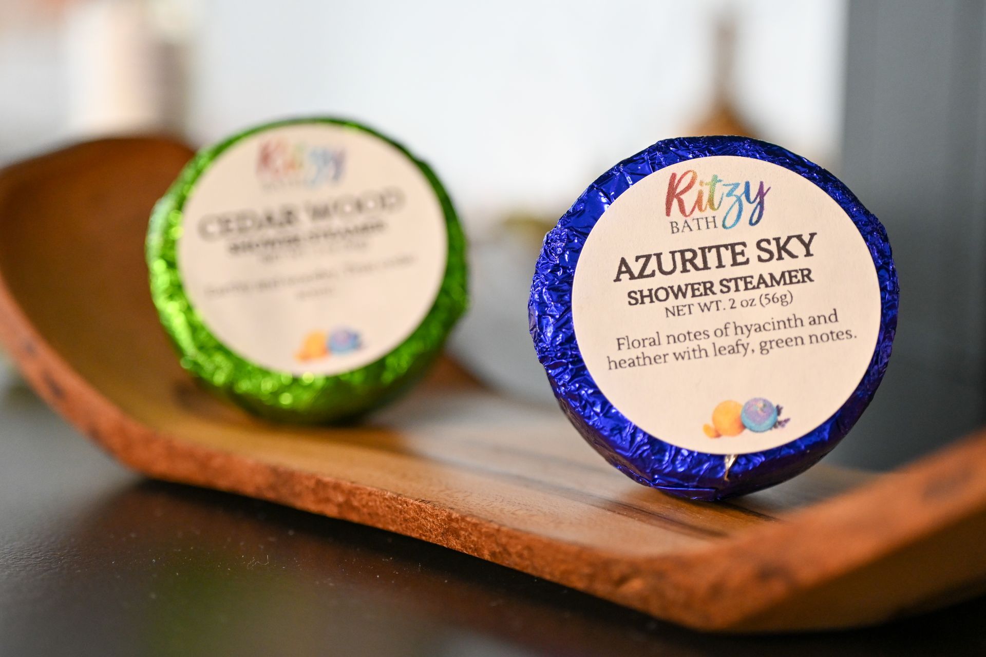 Two soaps are sitting on a wooden tray on a table.