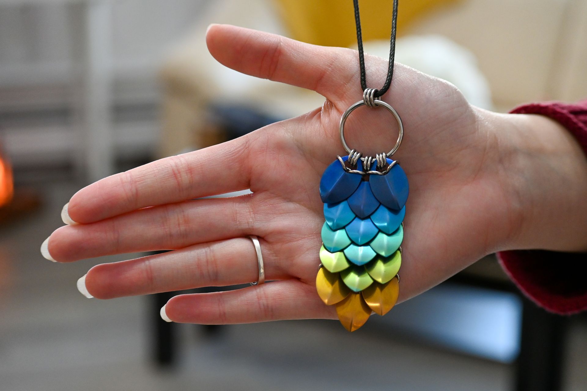 A person is holding a necklace in their hand