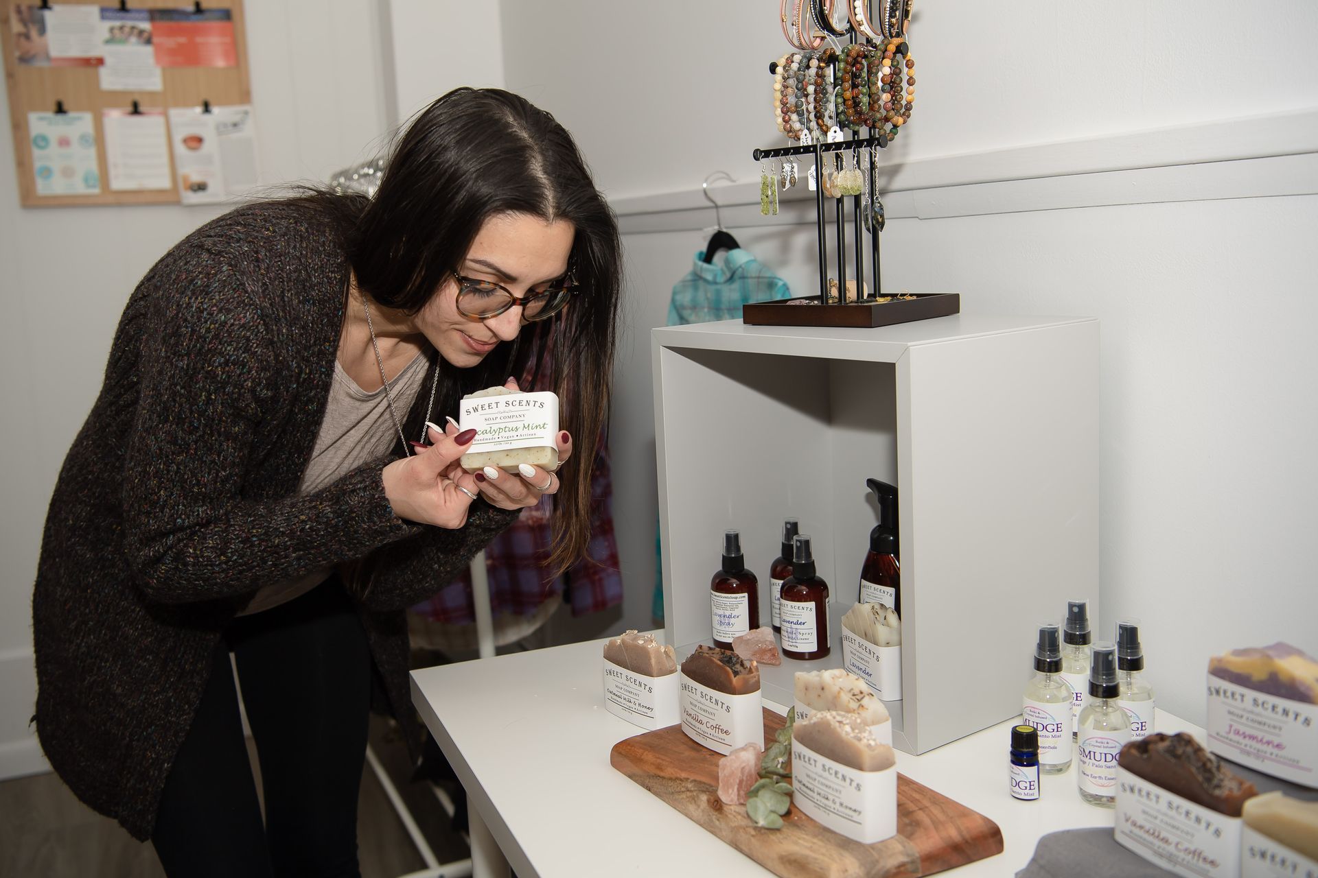 A woman is smelling a bar of soap in a store.
