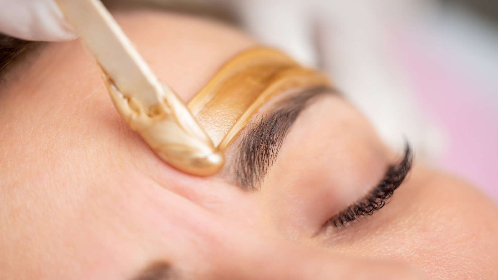 A woman is getting her eyebrows waxed in a beauty salon.