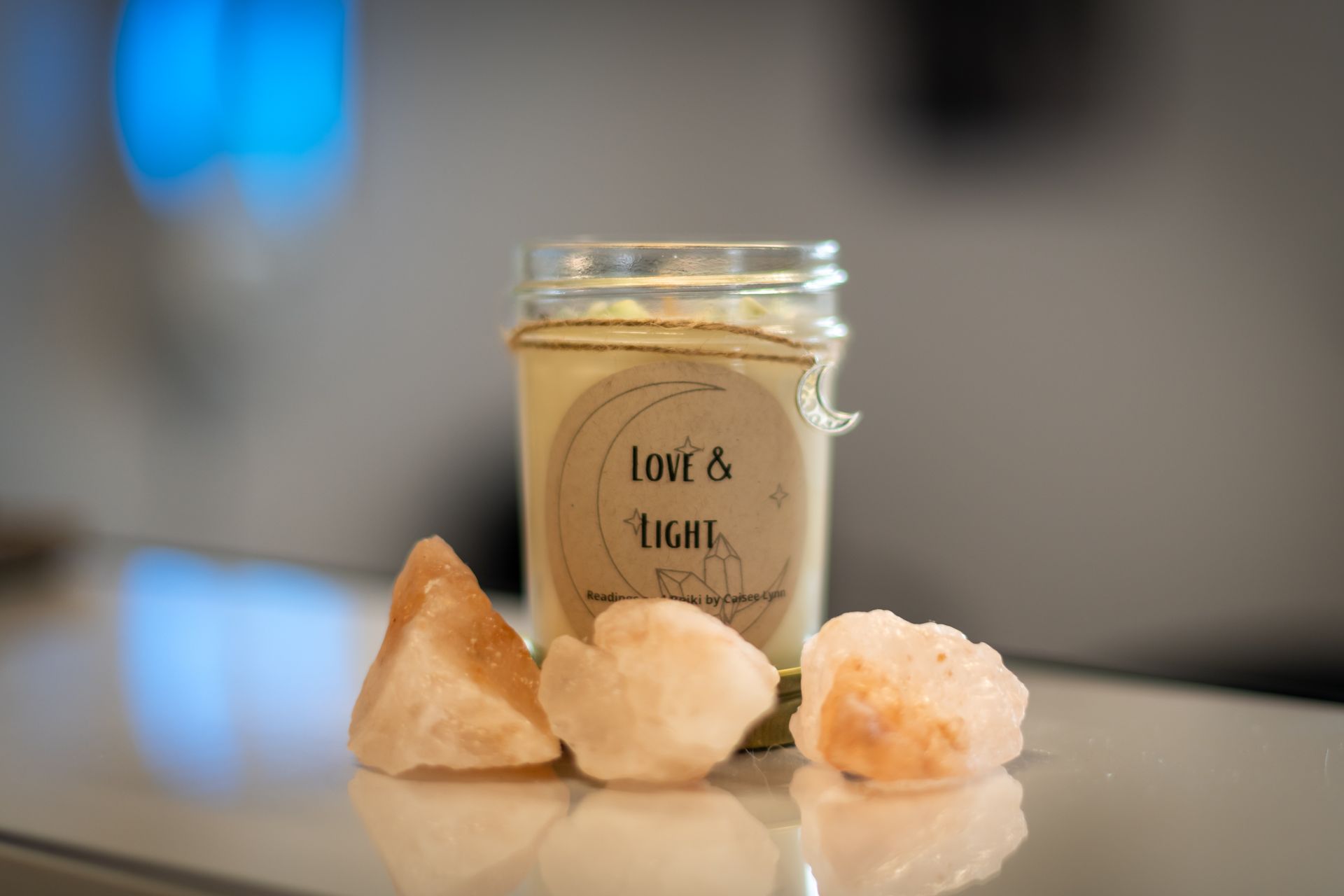 A candle is sitting on a table next to some rocks.
