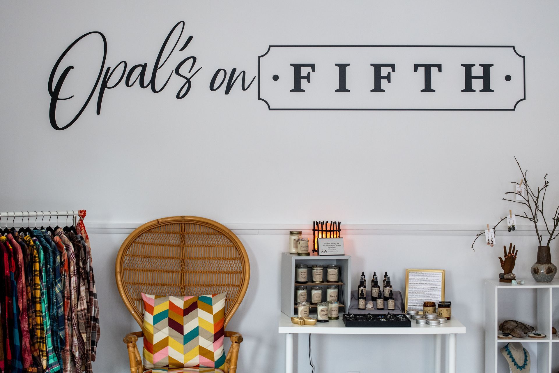 A room with a wicker chair and a sign that says opal 's on fifth