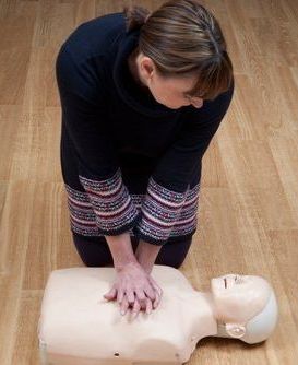 woman doing cpr on a dummy
