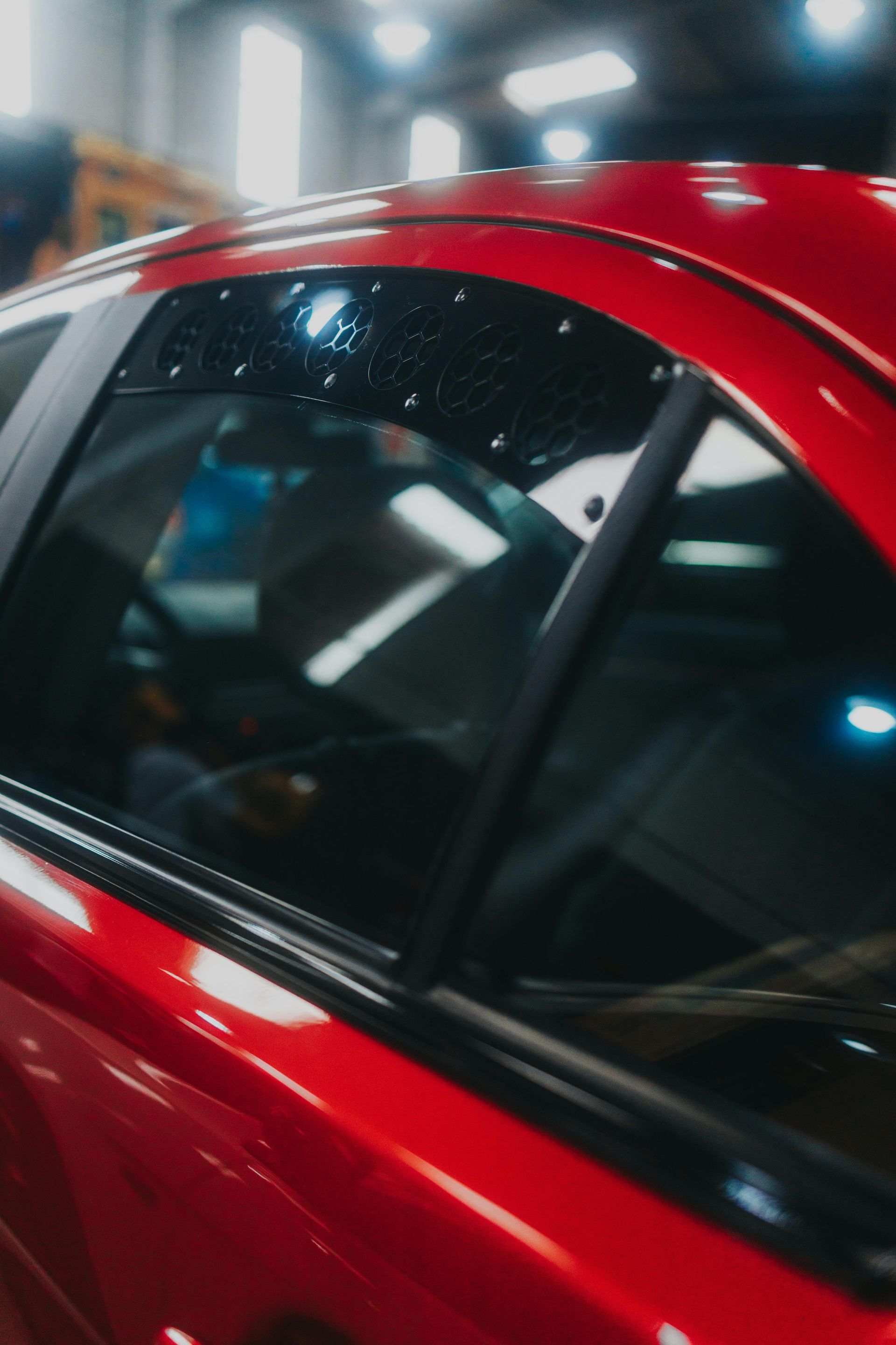 A close up of a red car in a garage
