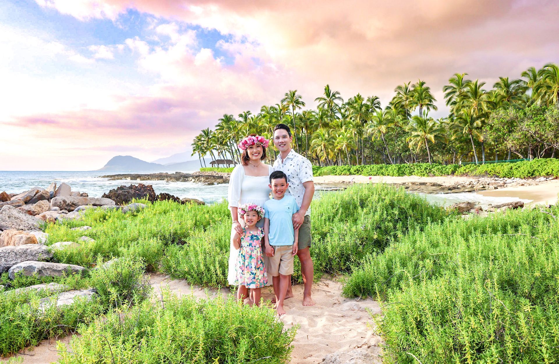 A family is posing for a picture on the beach.