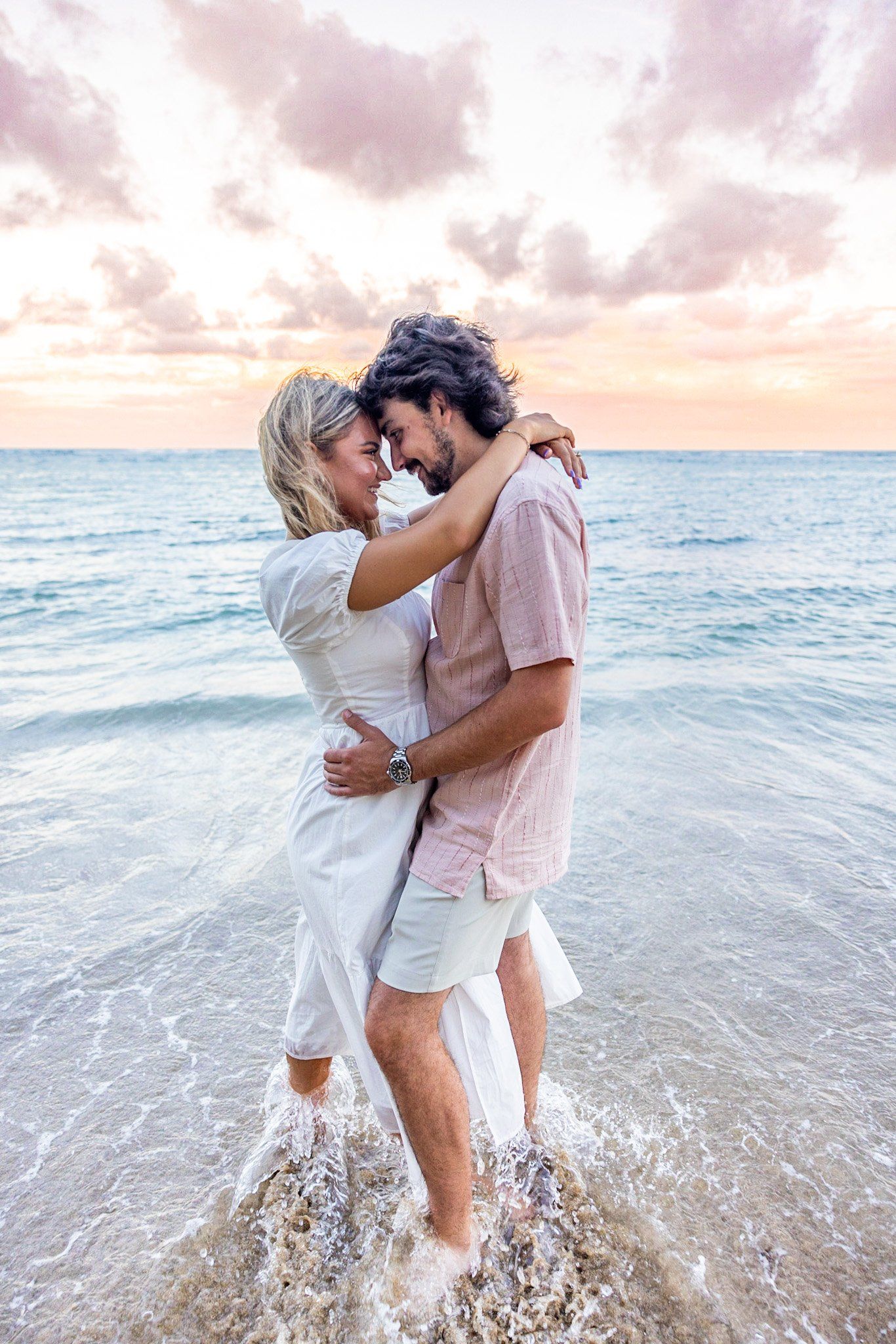 A man and a woman are hugging on the beach.