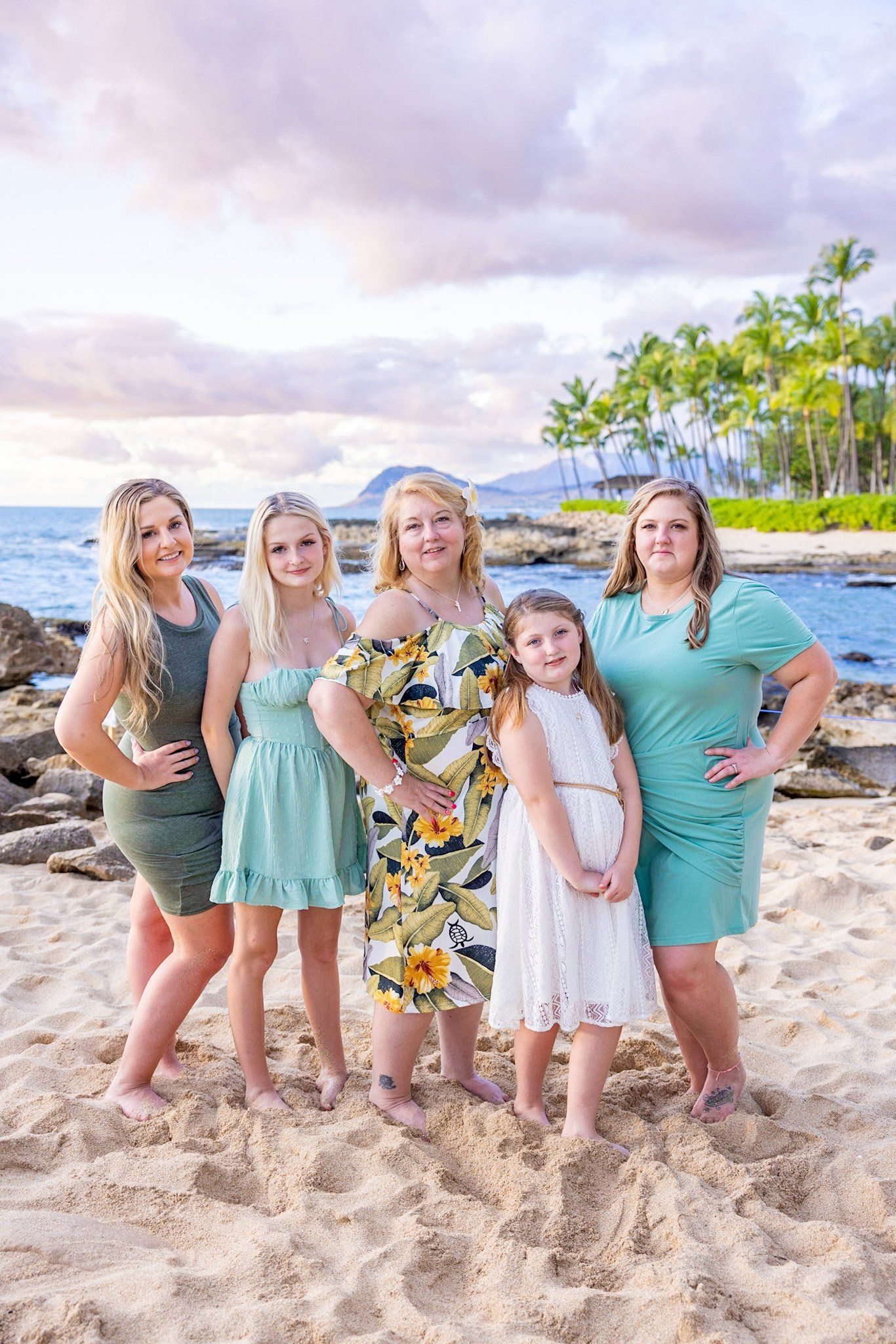 A group of women are posing for a picture on the beach.