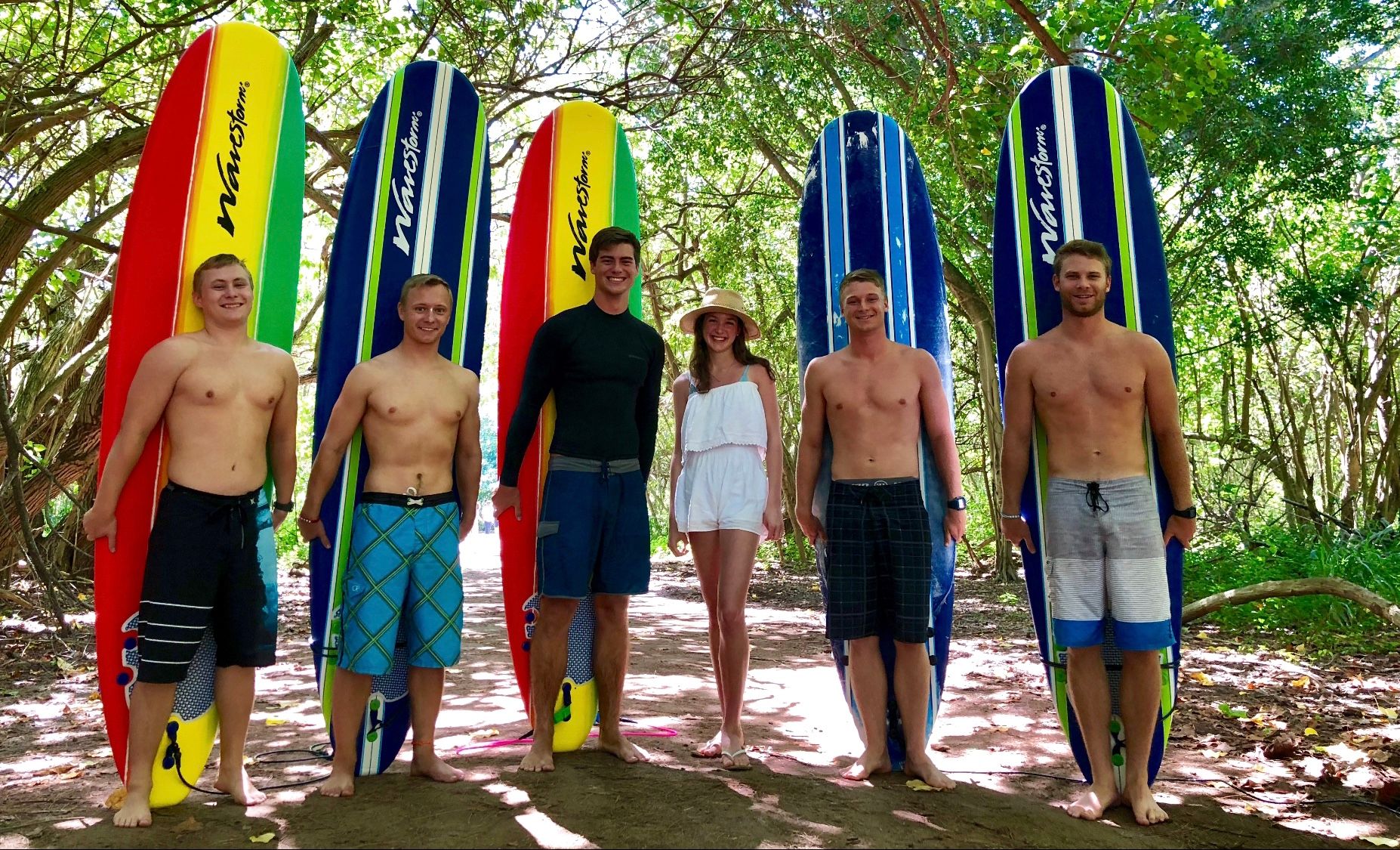 A group of people standing next to surfboards that say atlantis on them