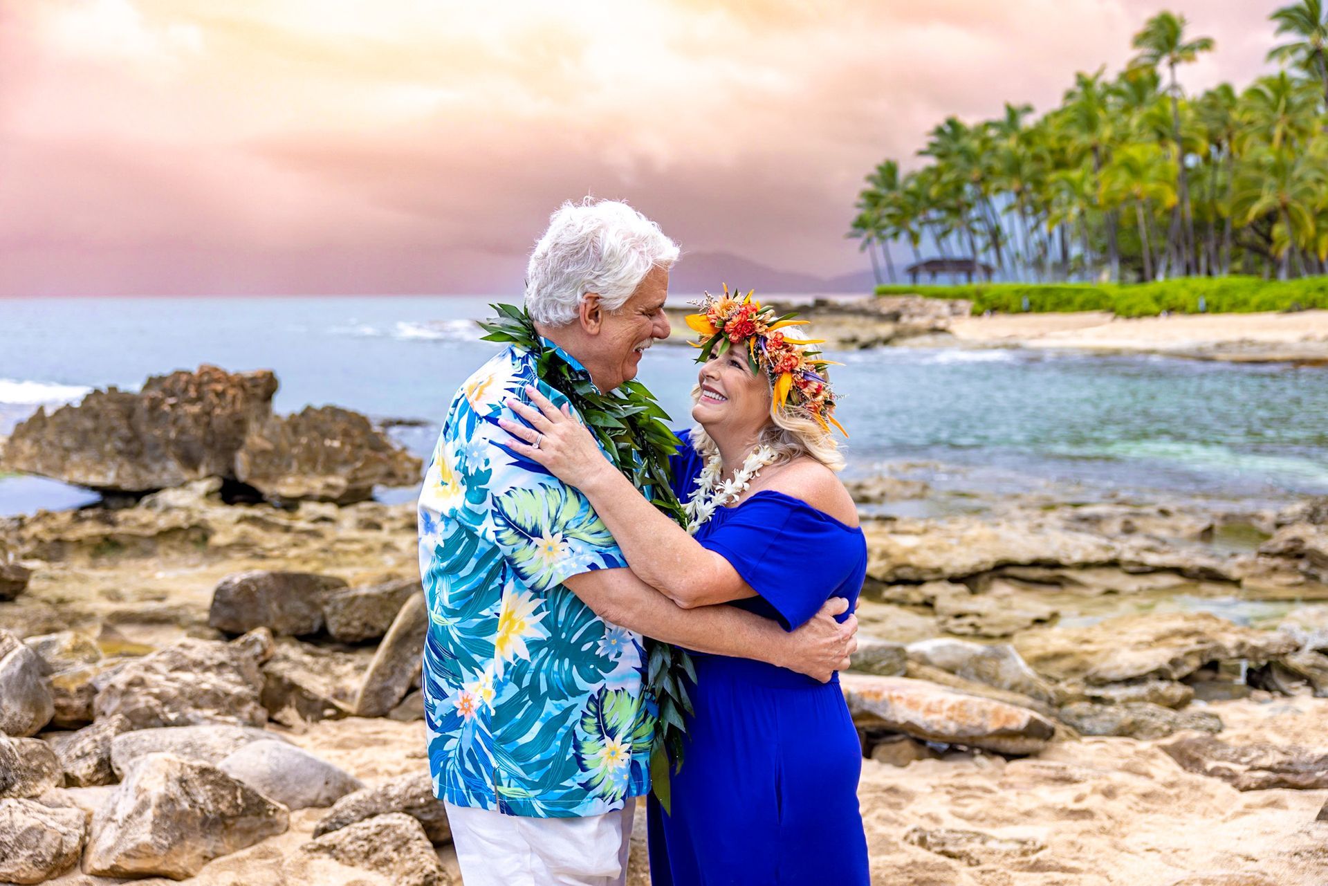 A man and a woman are hugging on the beach.