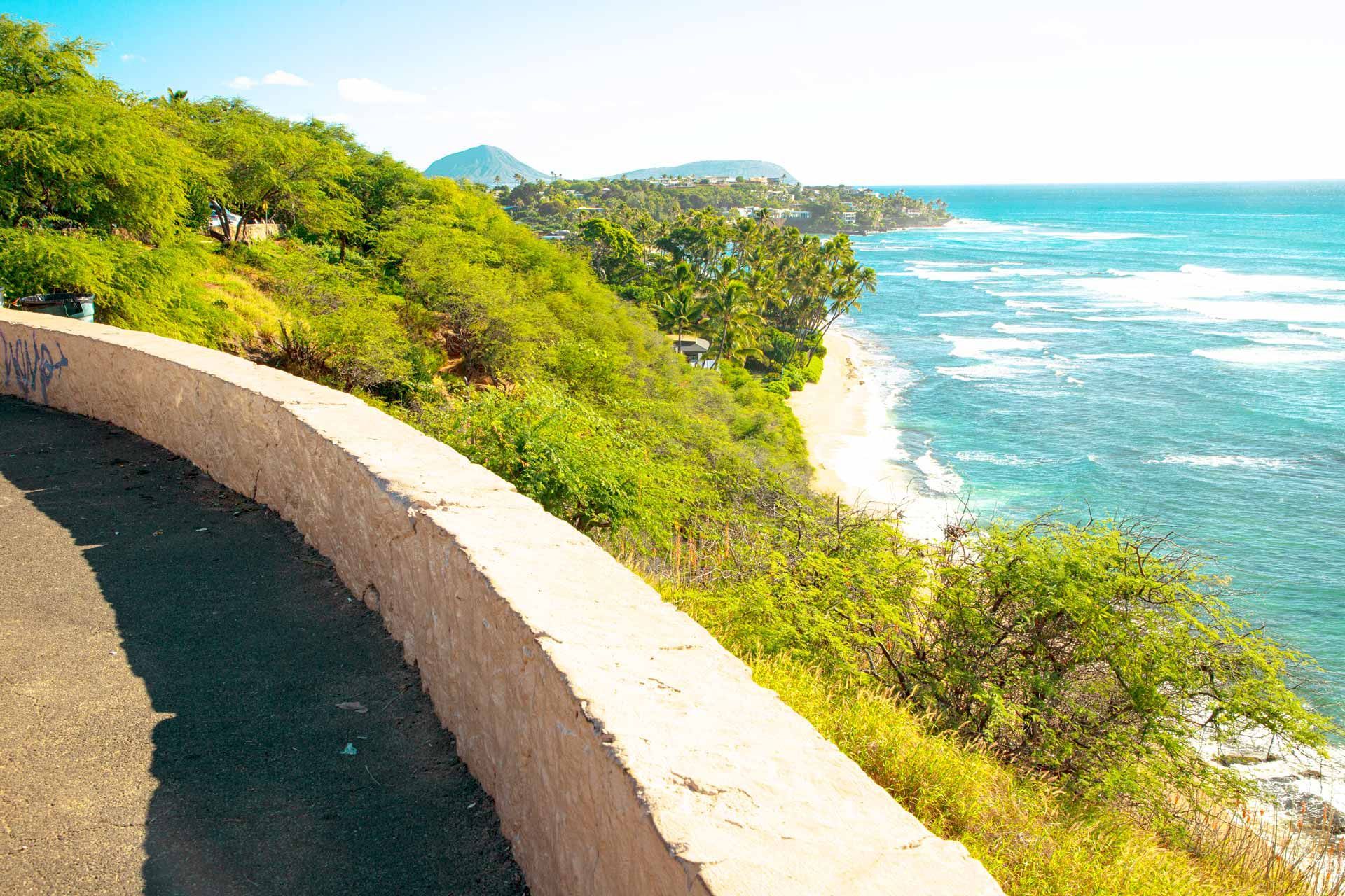 A road going down a cliff overlooking the ocean.