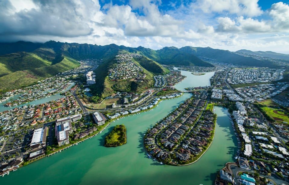 An aerial view of a city surrounded by water and mountains.
