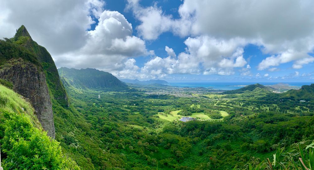 A view of a valley surrounded by mountains and trees.