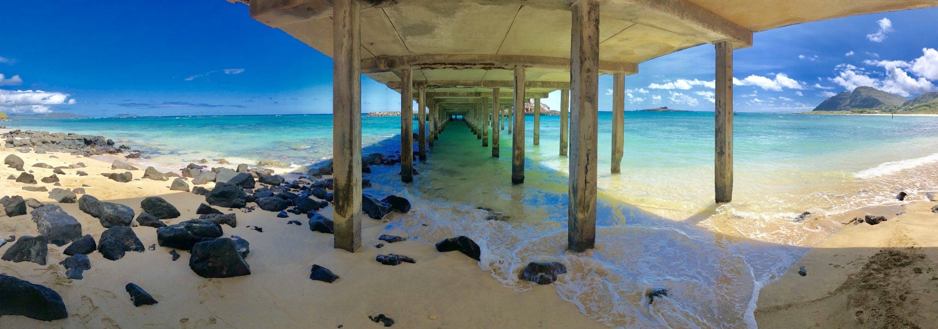 A pier leading to the ocean on a sunny day.