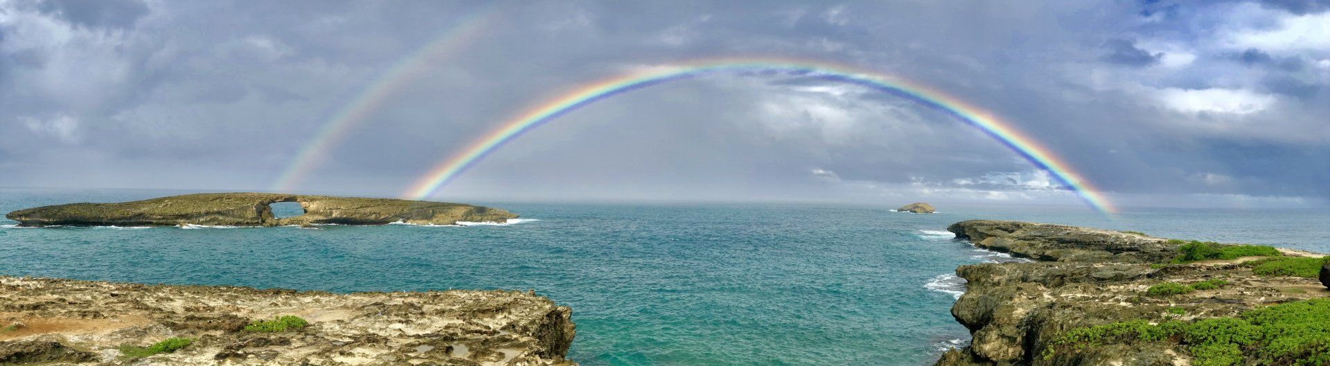 There is a double rainbow over the ocean.