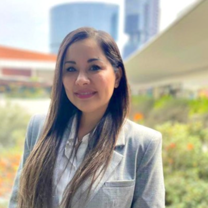 A woman in a suit and white shirt is smiling for the camera.