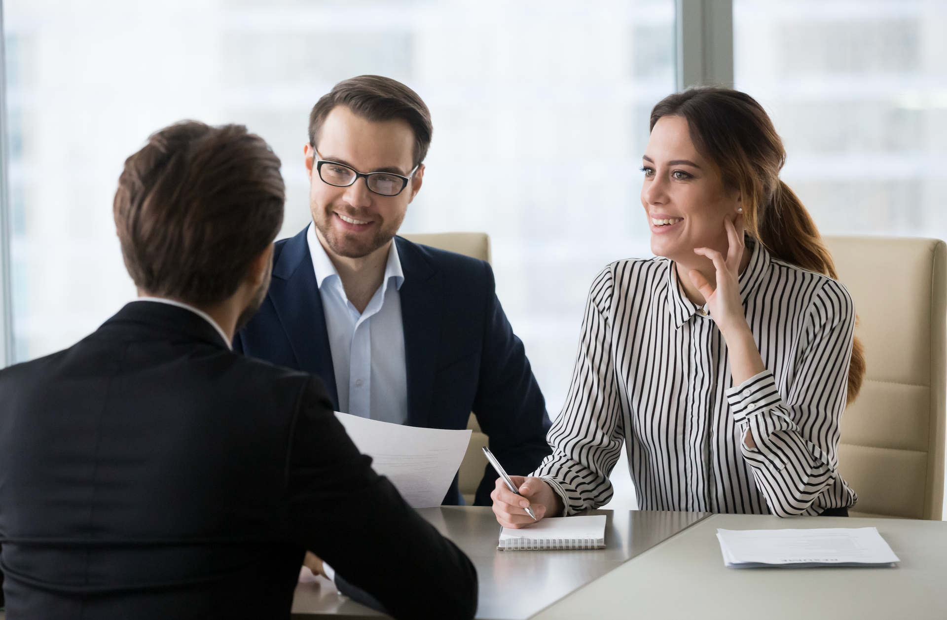 A man and a woman are sitting at a table having a job interview.