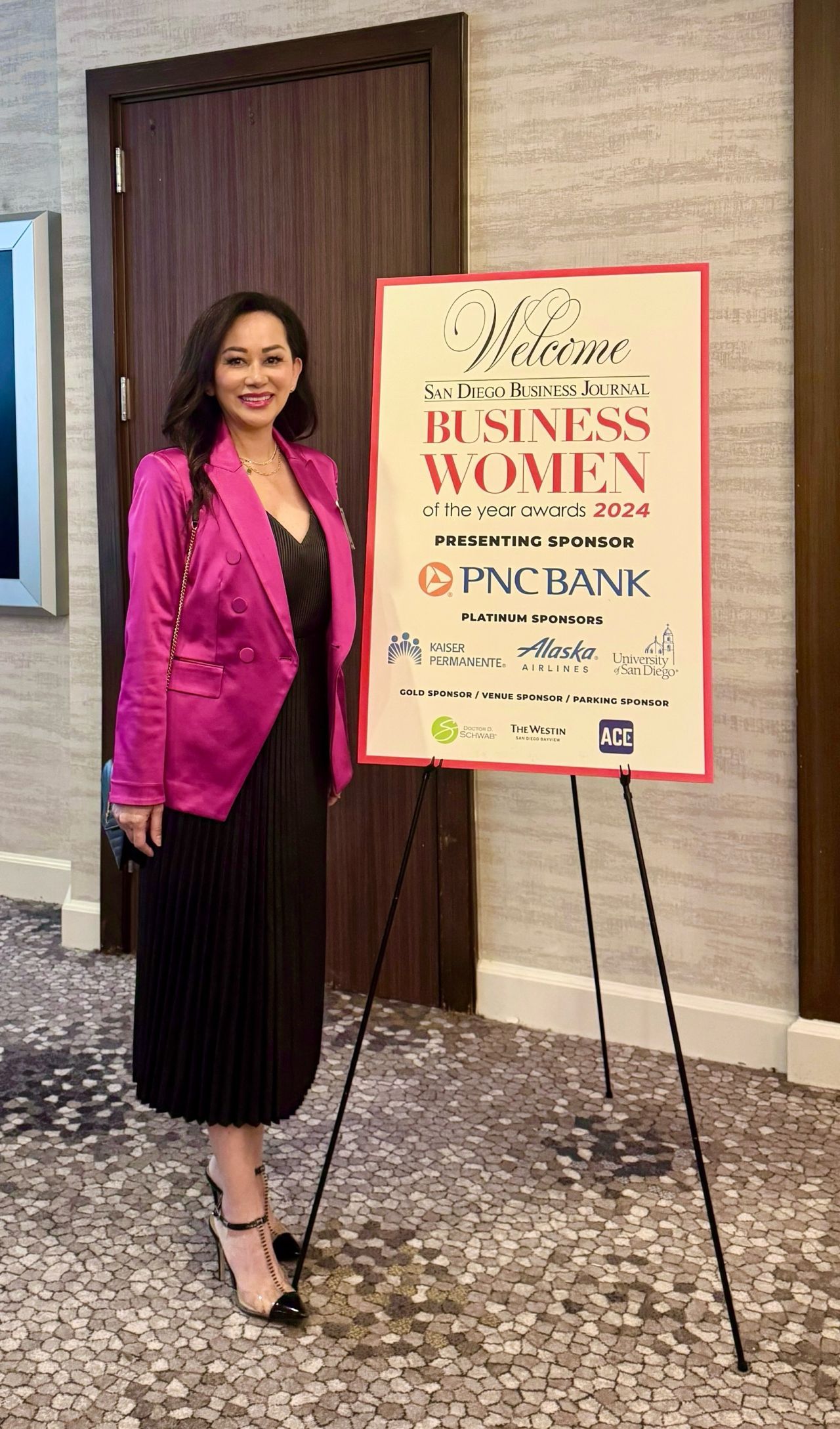 A woman is standing in front of a sign that says business women.