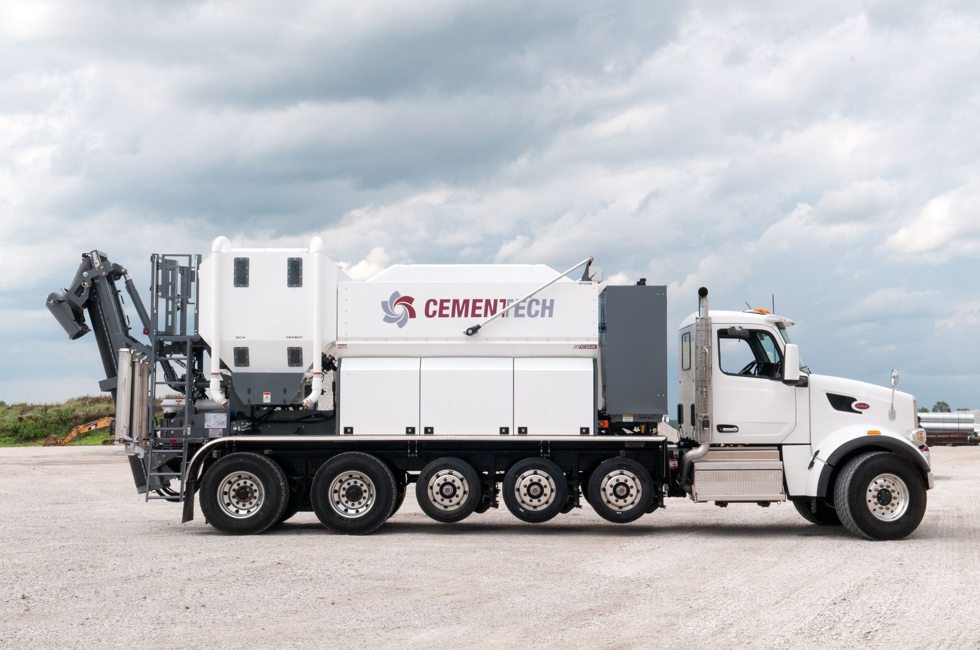 White Cementech truck  with Volumetric Mixers on job site.