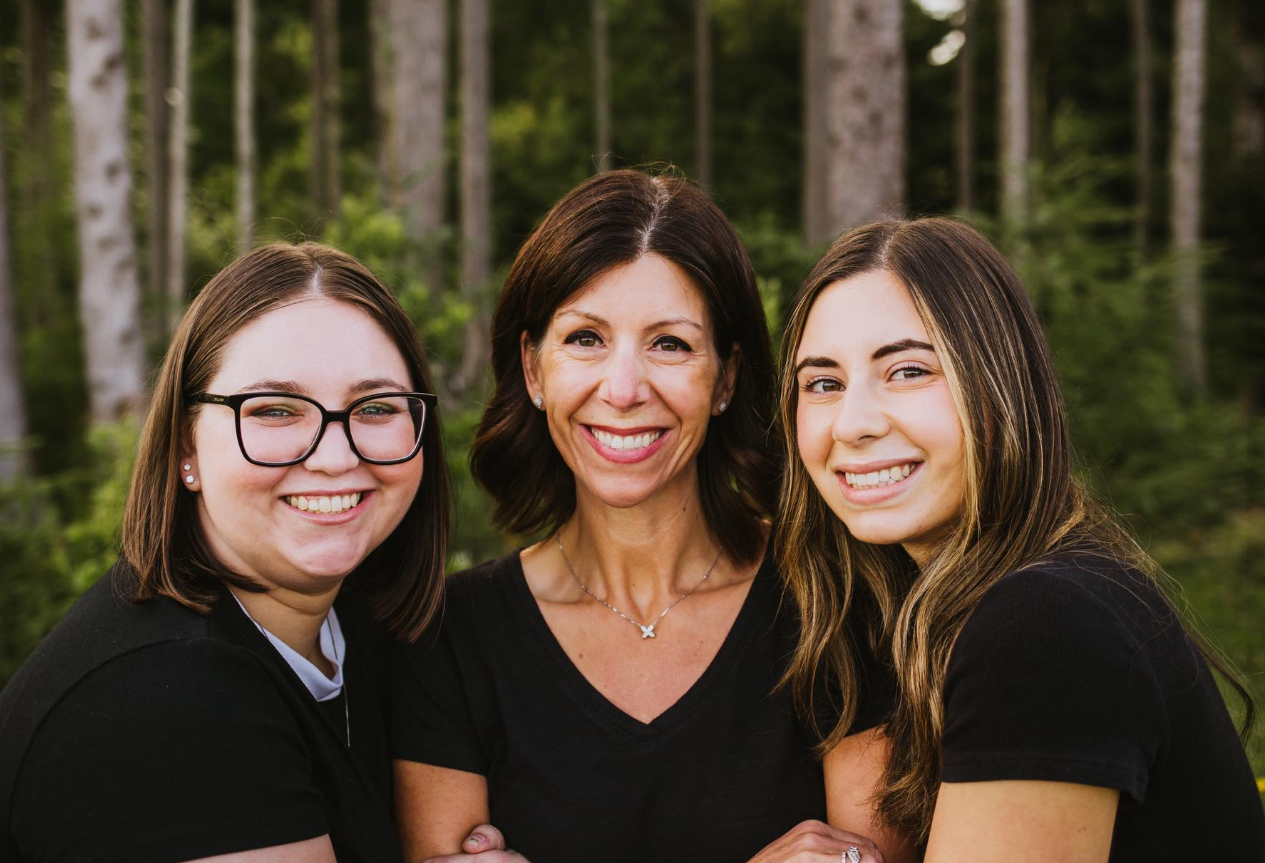 Two women are sitting at a table with a view of the ocean