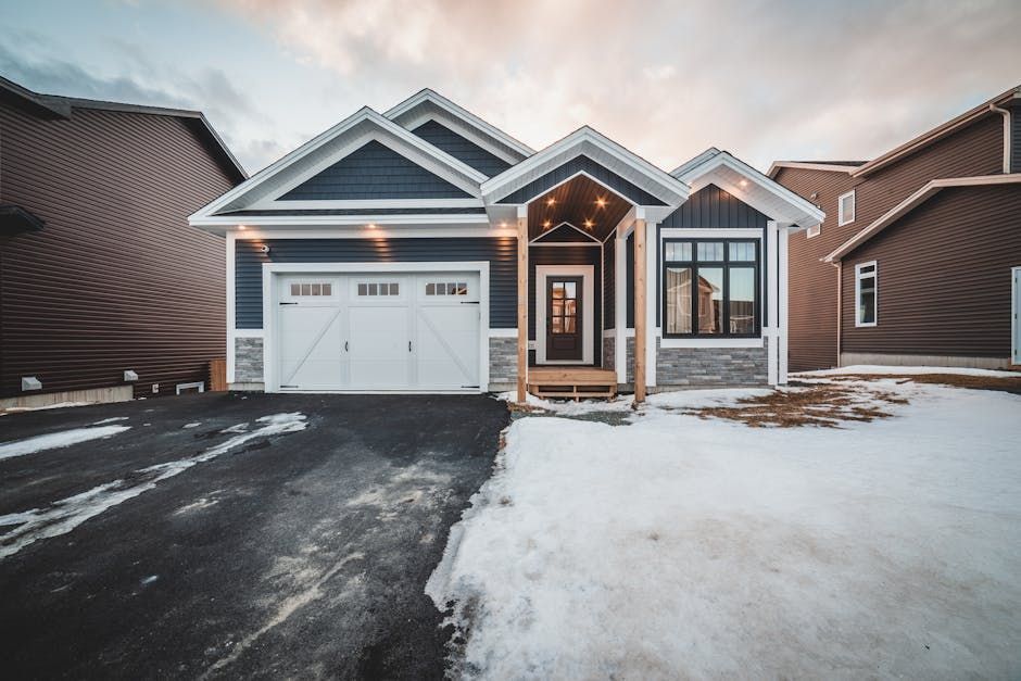 A house with a garage and a driveway covered in snow.
