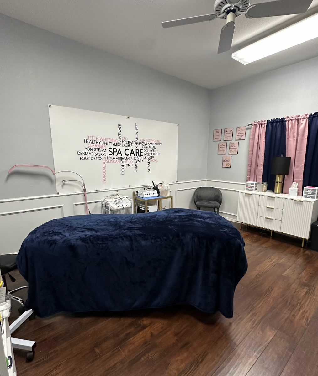 A room with a massage table and a ceiling fan