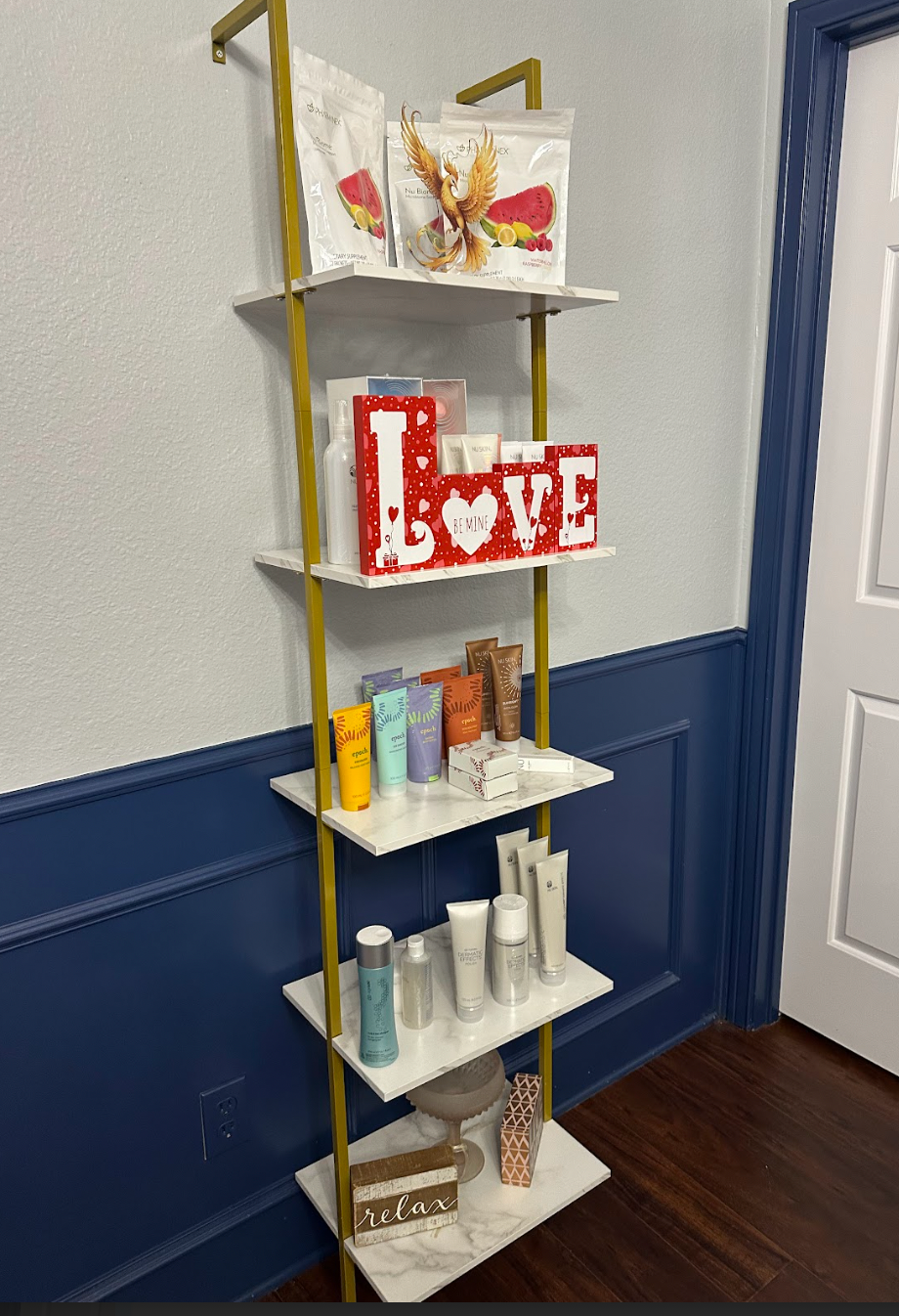 A shelf filled with lots of cosmetics and a sign that says `` love ''.