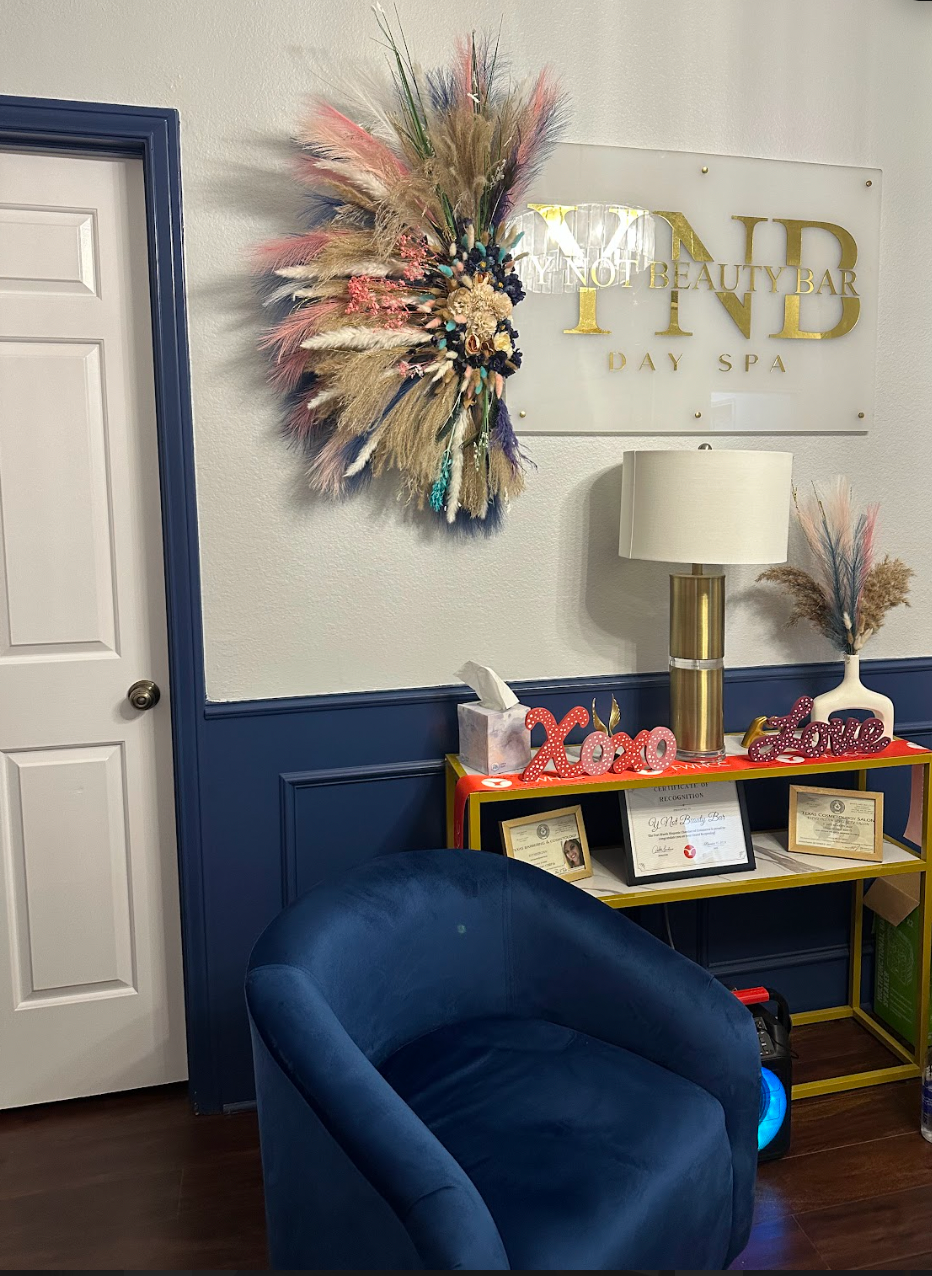 A blue chair is sitting in a room with a wreath on the wall.