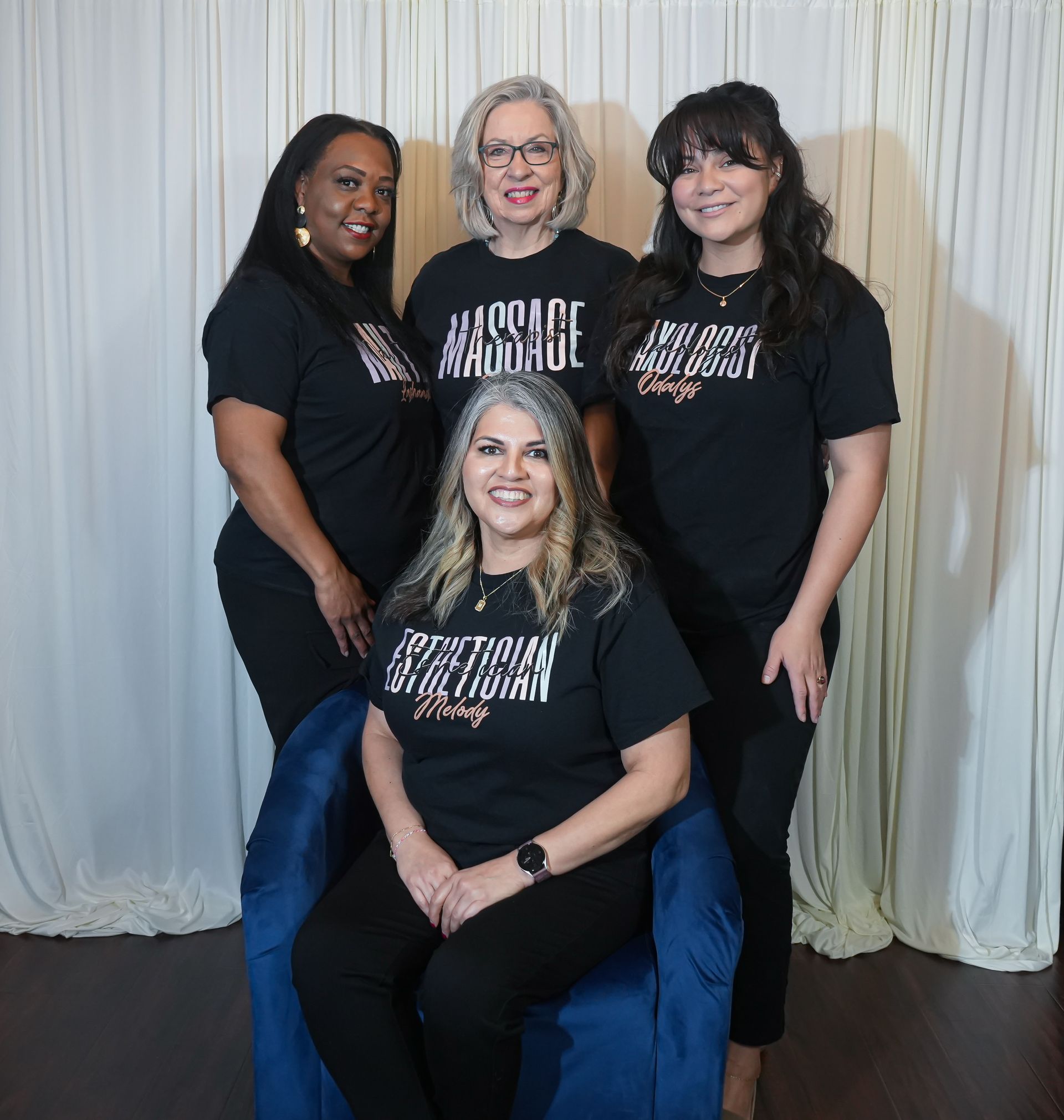 Three women are posing for a picture and one of them is wearing a purple scarf.
