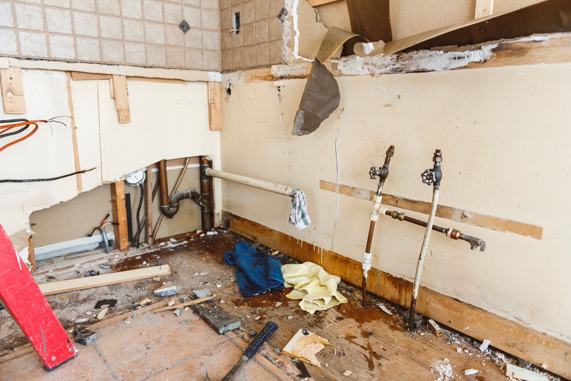 A bathroom under construction with a ladder and tools on the floor.