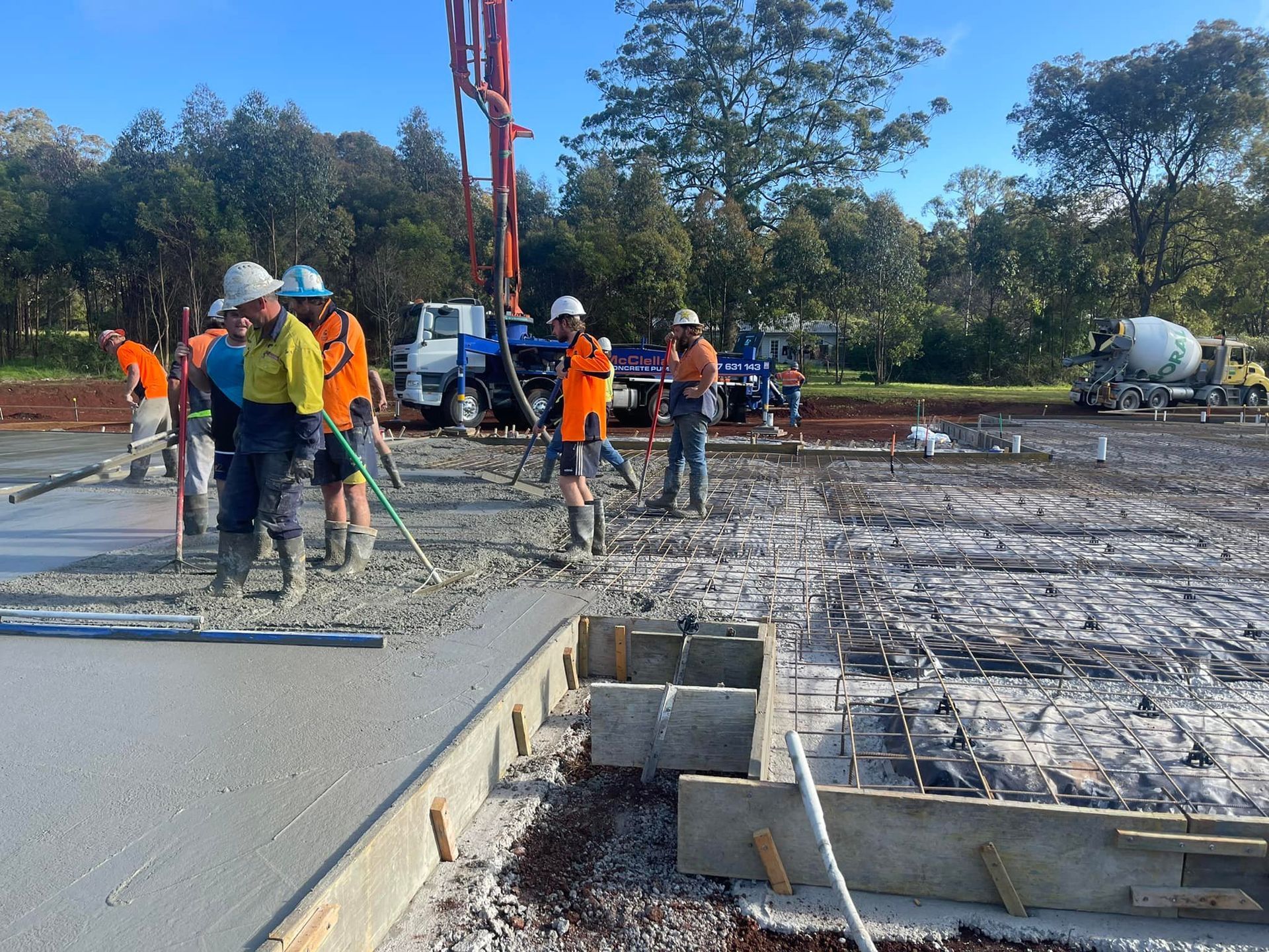 A group of construction workers are working on a concrete floor. — Windamere Homes in Highfields, QLD
