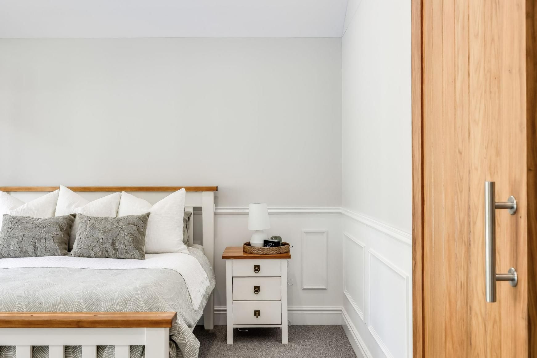 A Bedroom With a Bed , Nightstand , and Door — Windamere Homes in Highfields, QLD