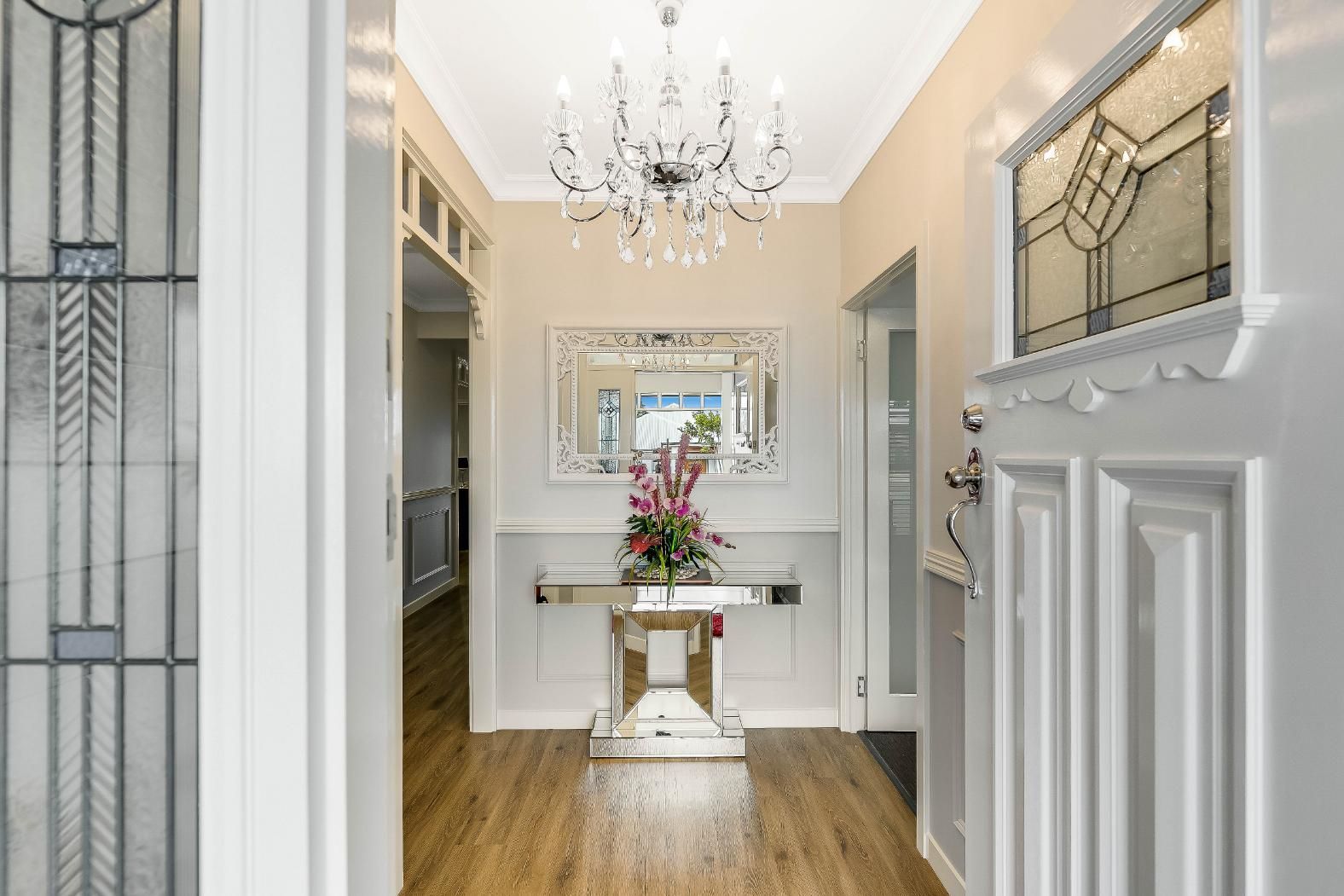 A Hallway in a House With Table and Chandelier — Windamere Homes in Highfields, QLD