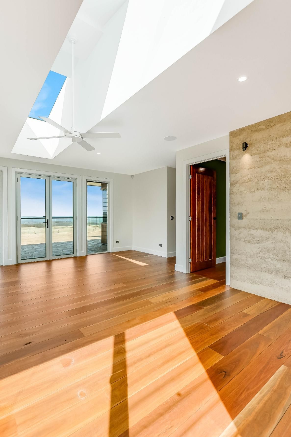 An Empty Living Room With Hardwood Floors — Windamere Homes in Highfields, QLD