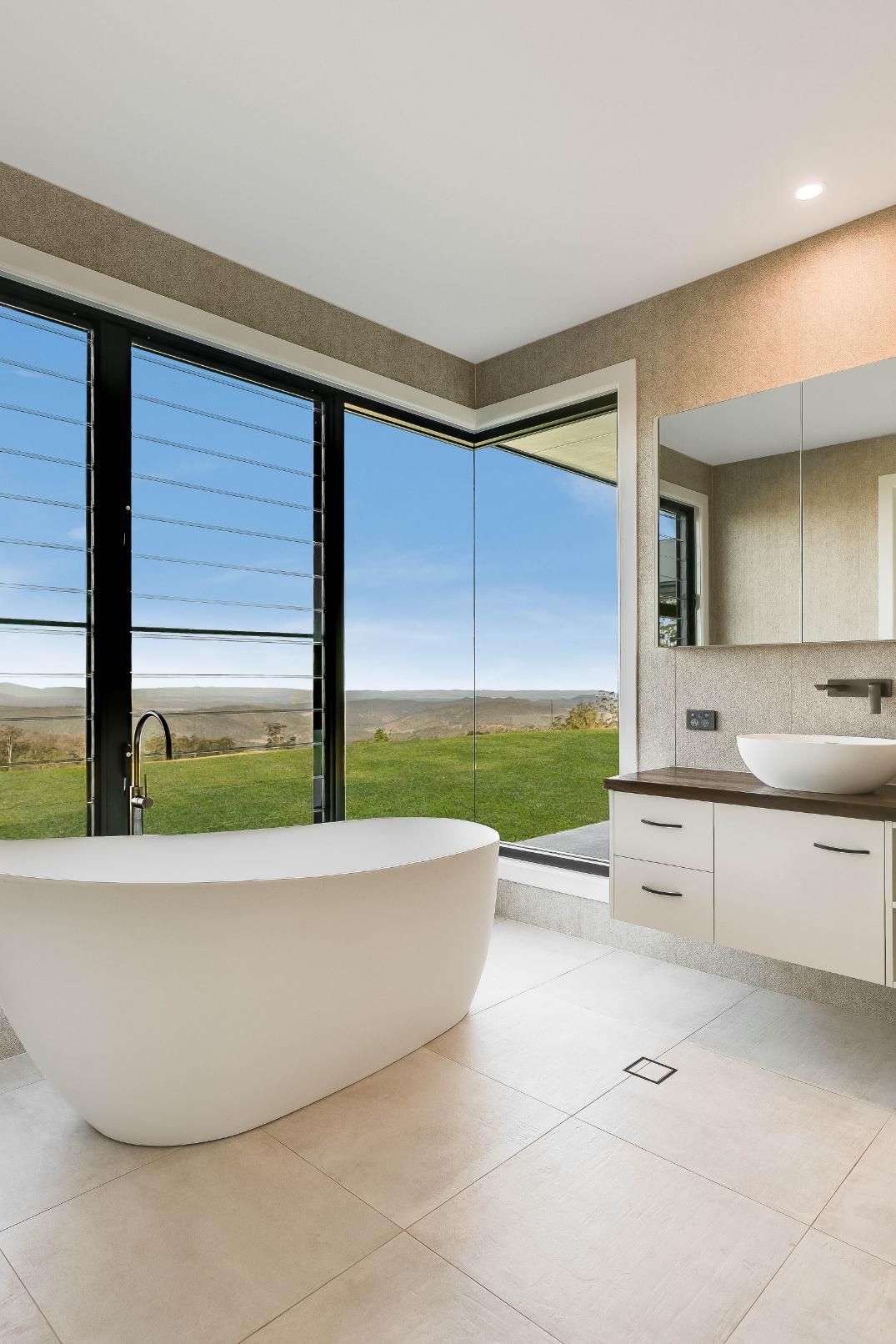 A Bathroom With a Tub and Mirror — Windamere Homes in Highfields, QLD