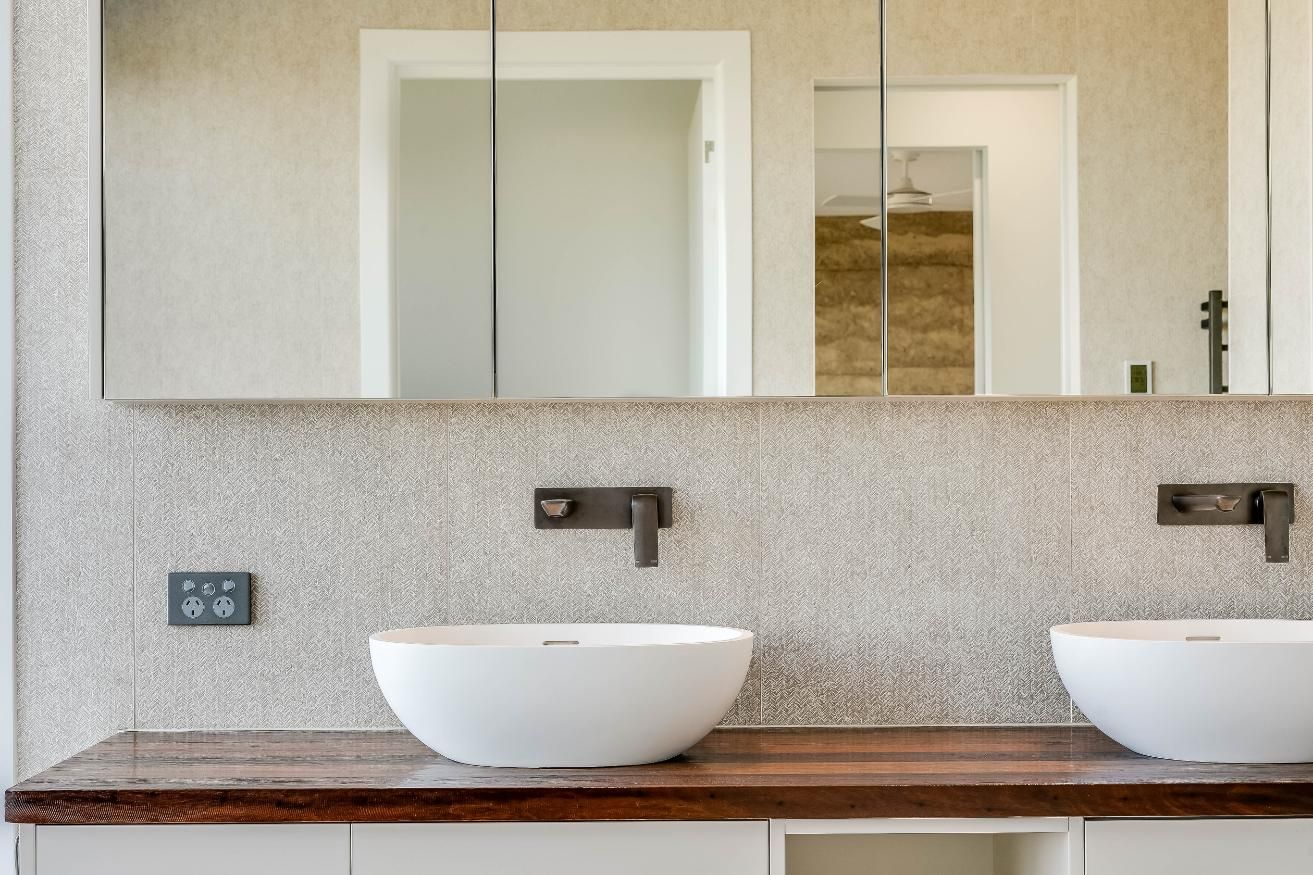 A Bathroom With Two Sinks and a Mirror — Windamere Homes in Highfields, QLD