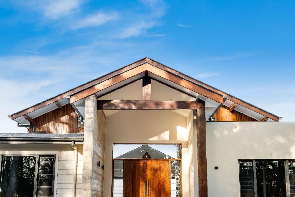 The Front of a House With a Wooden Door and a Copper Roof — Windamere Homes in Highfields, QLD