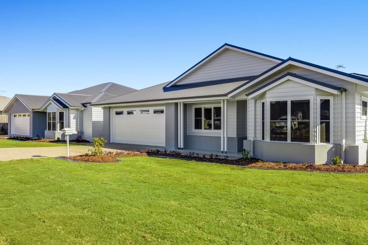A White House With a Large Lawn in Front of It — Windamere Homes in Highfields, QLD