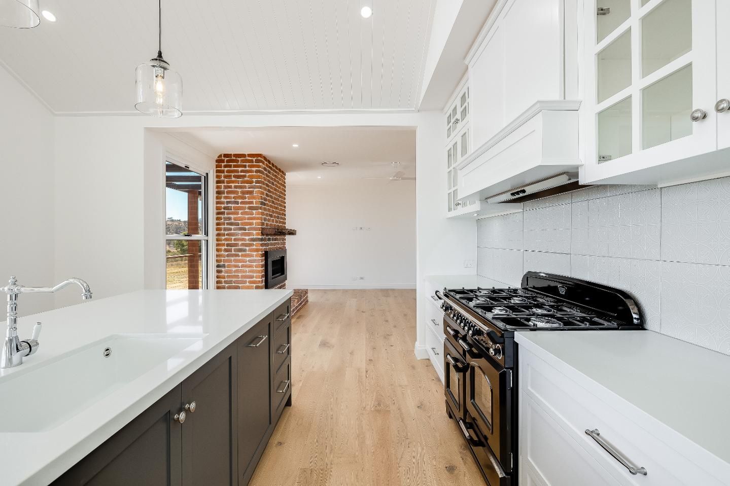 A Kitchen With a Stove , Sink , and Cabinets — Windamere Homes in Highfields, QLD