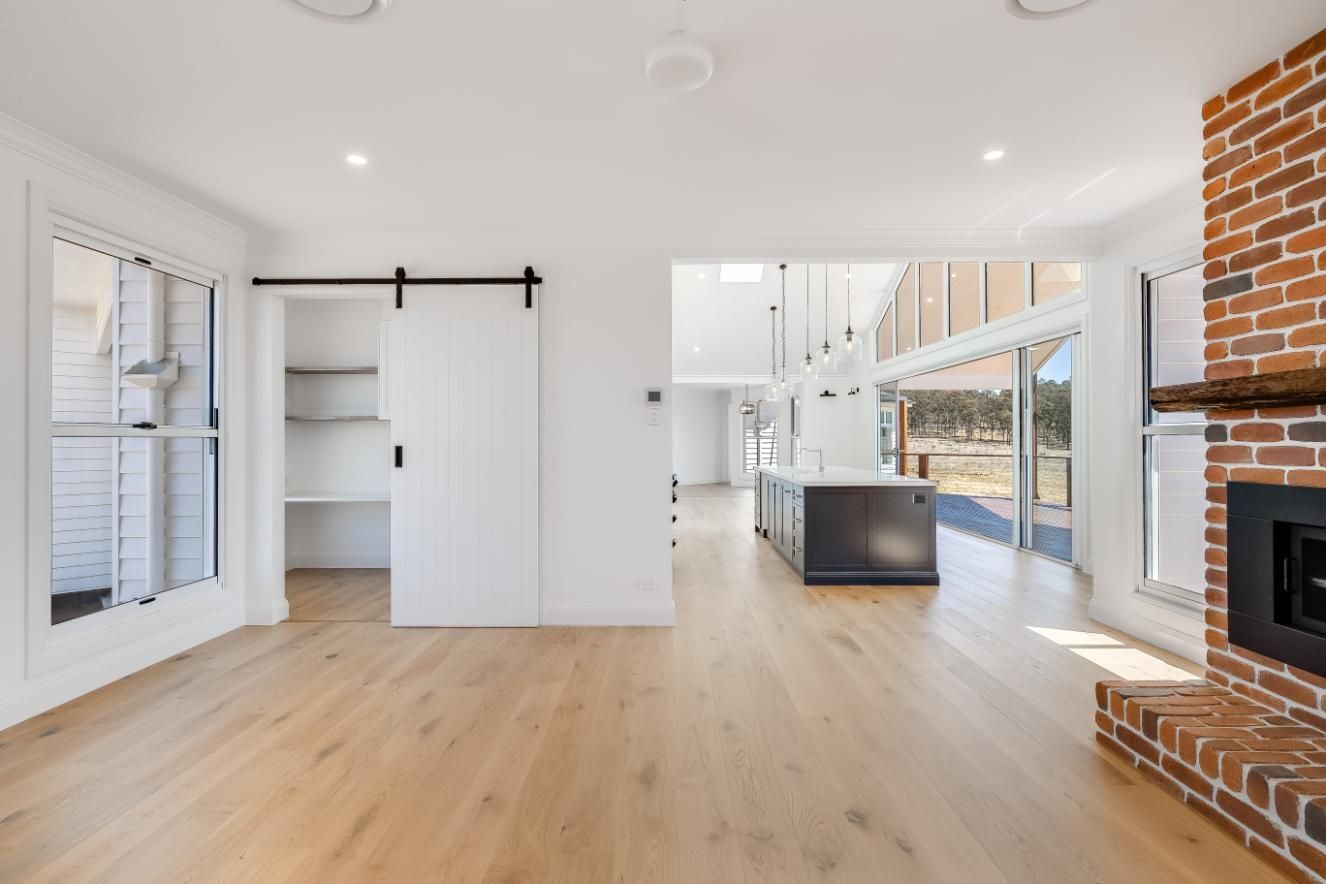 An Empty Living Room With Hardwood Floors — Windamere Homes in Highfields, QLD