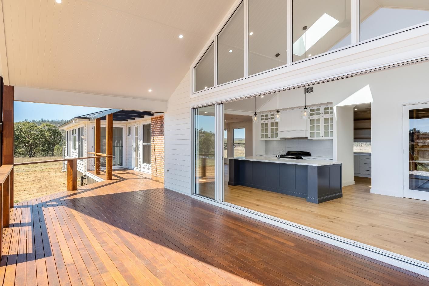 A Kitchen With Sliding Glass Doors and a Wooden Deck — Windamere Homes in Highfields, QLD