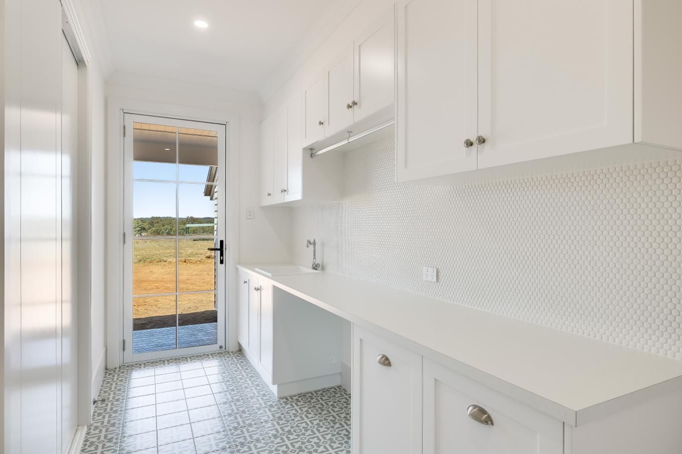 A Laundry Room With White Cabinets , a Sink — Windamere Homes in Highfields, QLD