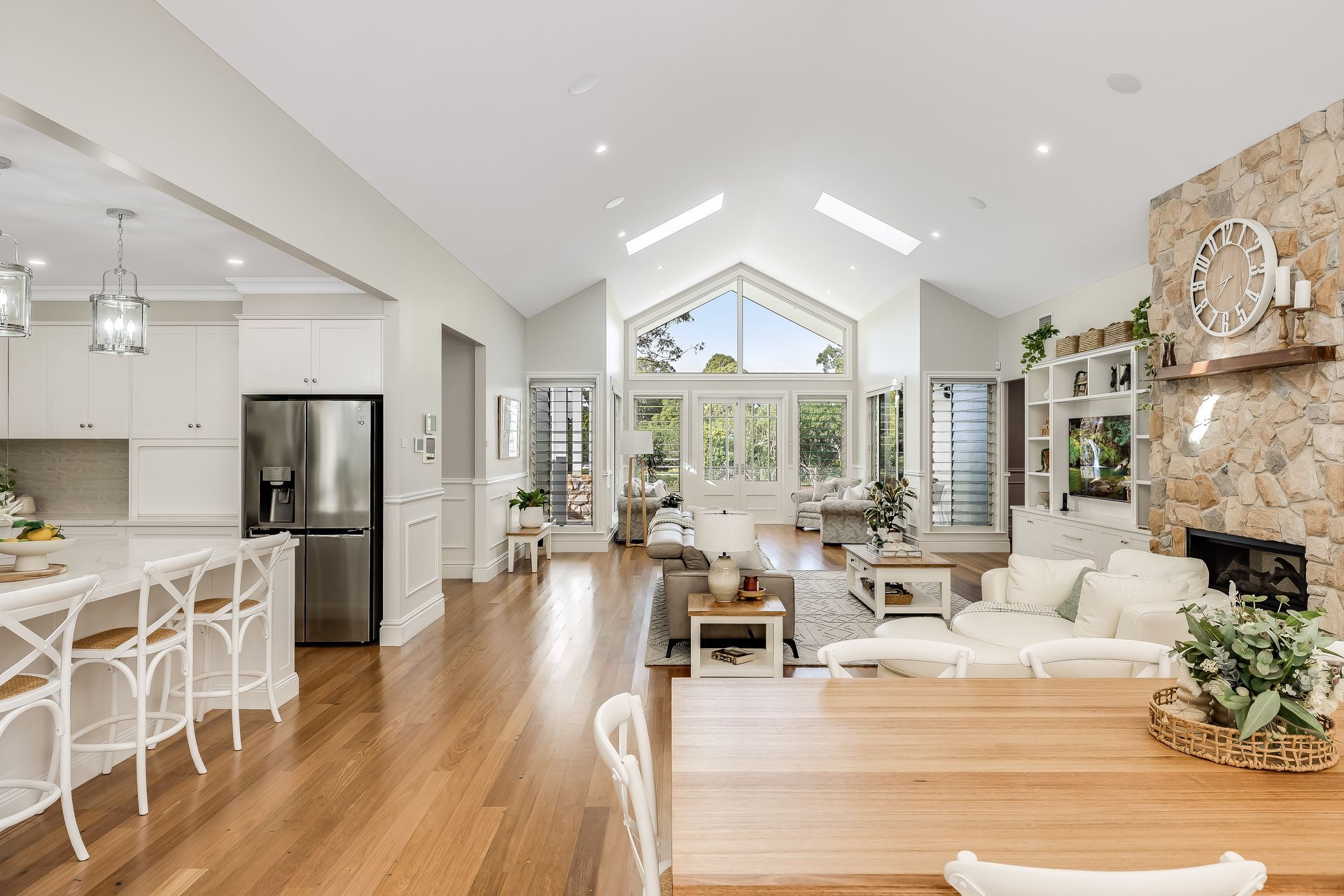 A living room and dining room in a house with a vaulted ceiling. — Windamere Homes in Highfields, QLD