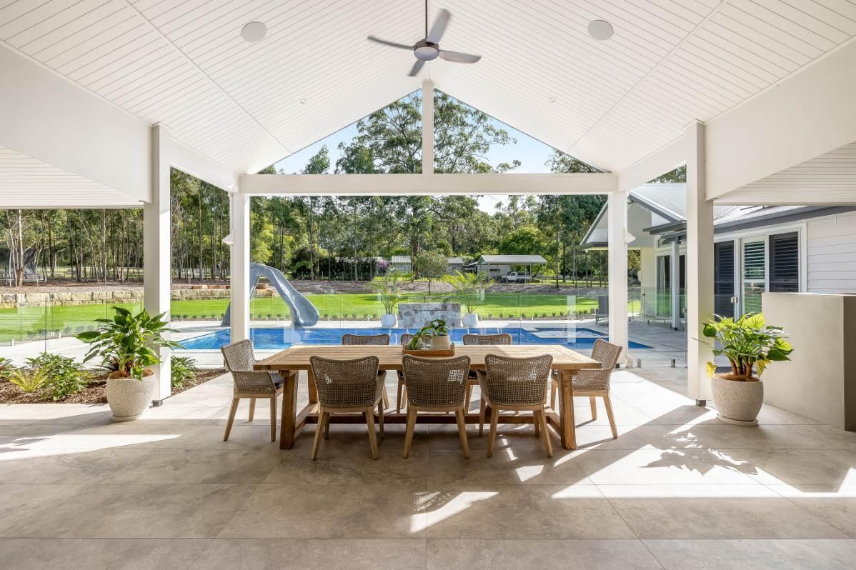 A Large Patio With a Table and Chairs — Windamere Homes in Highfields, QLD